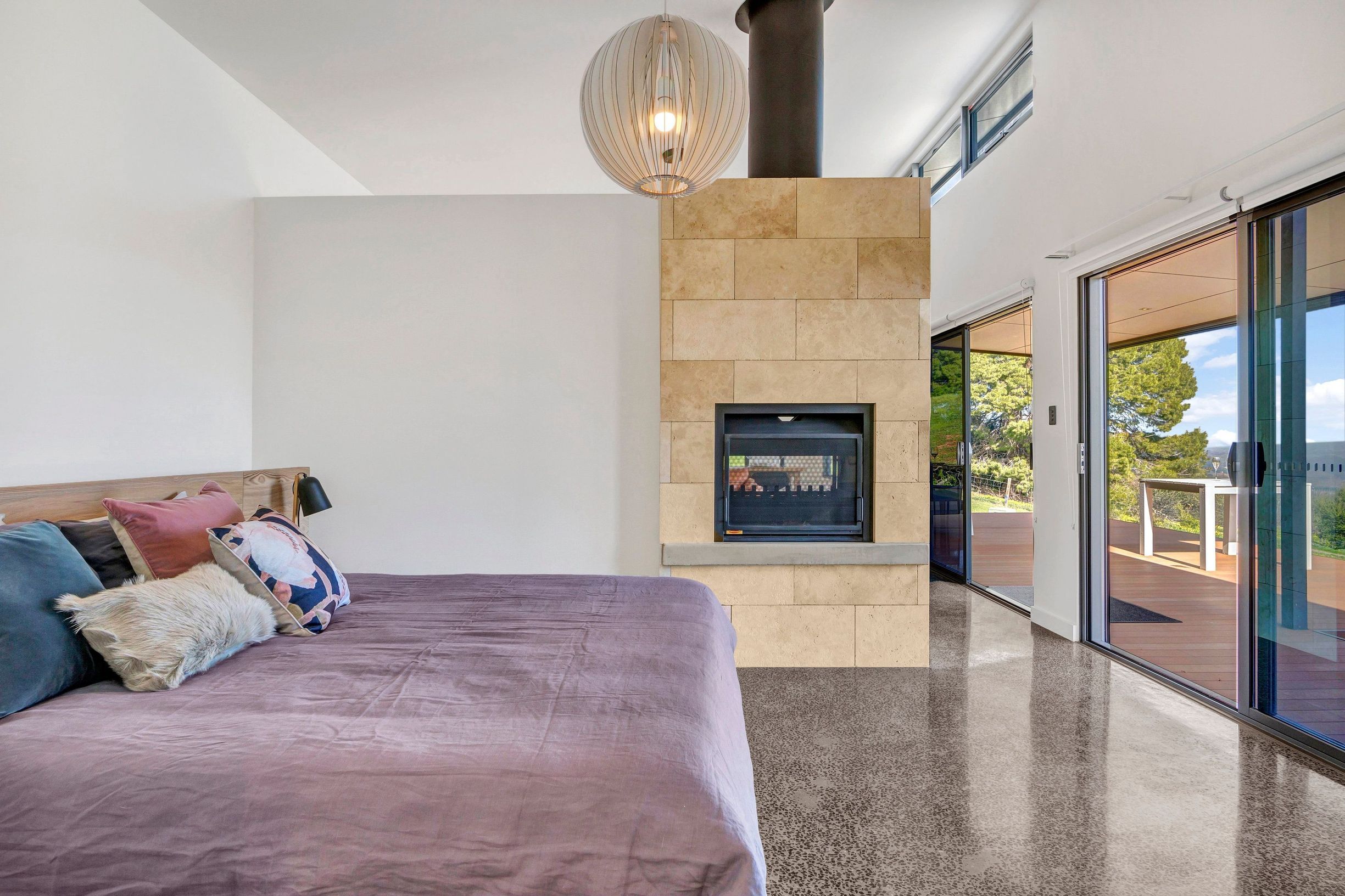 A big bed at Shadow Creek inside boutique accommodation,. with a fireplace