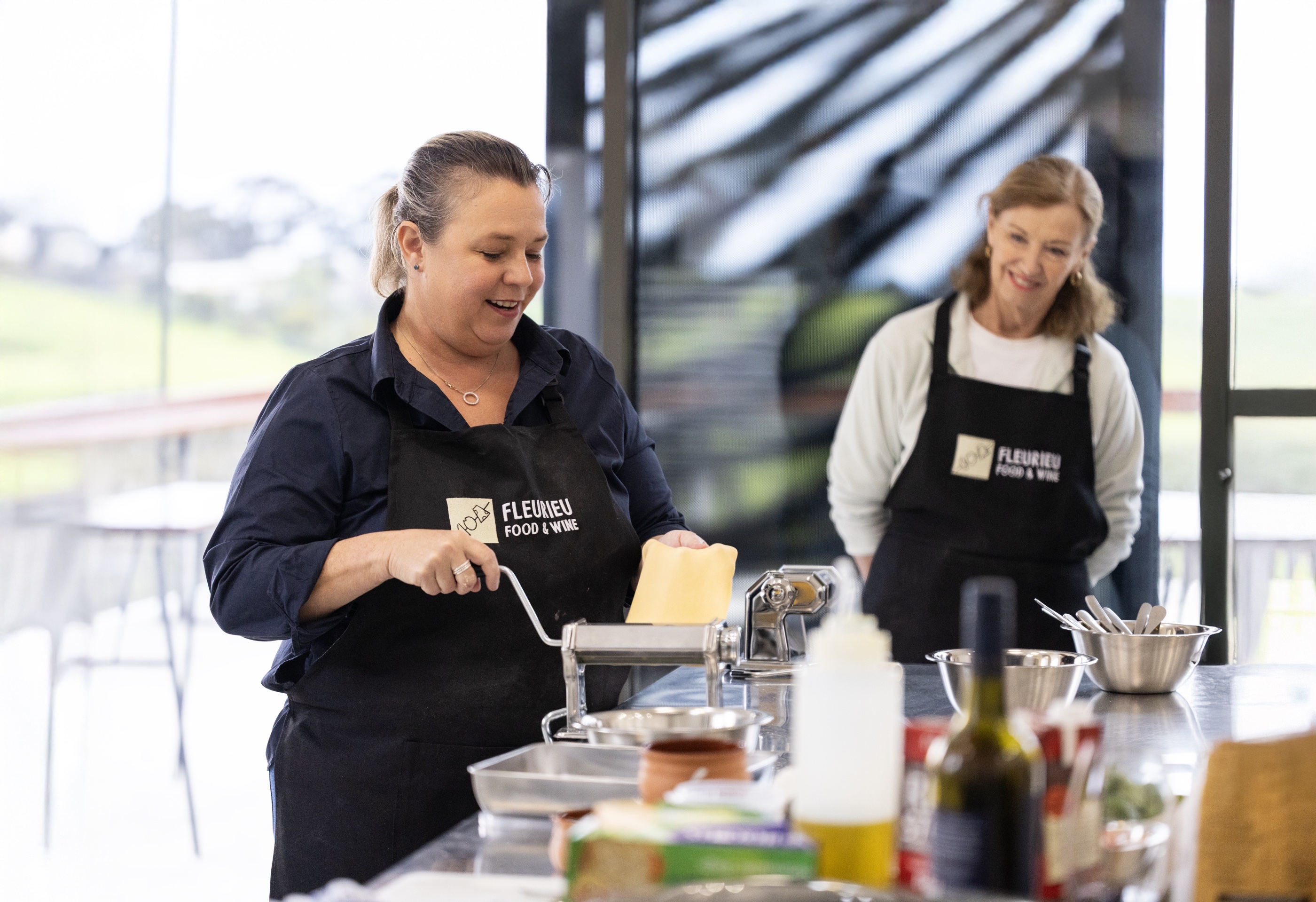 Two ladies with black aprons conducting a food demonstration at the fleurieu food festival