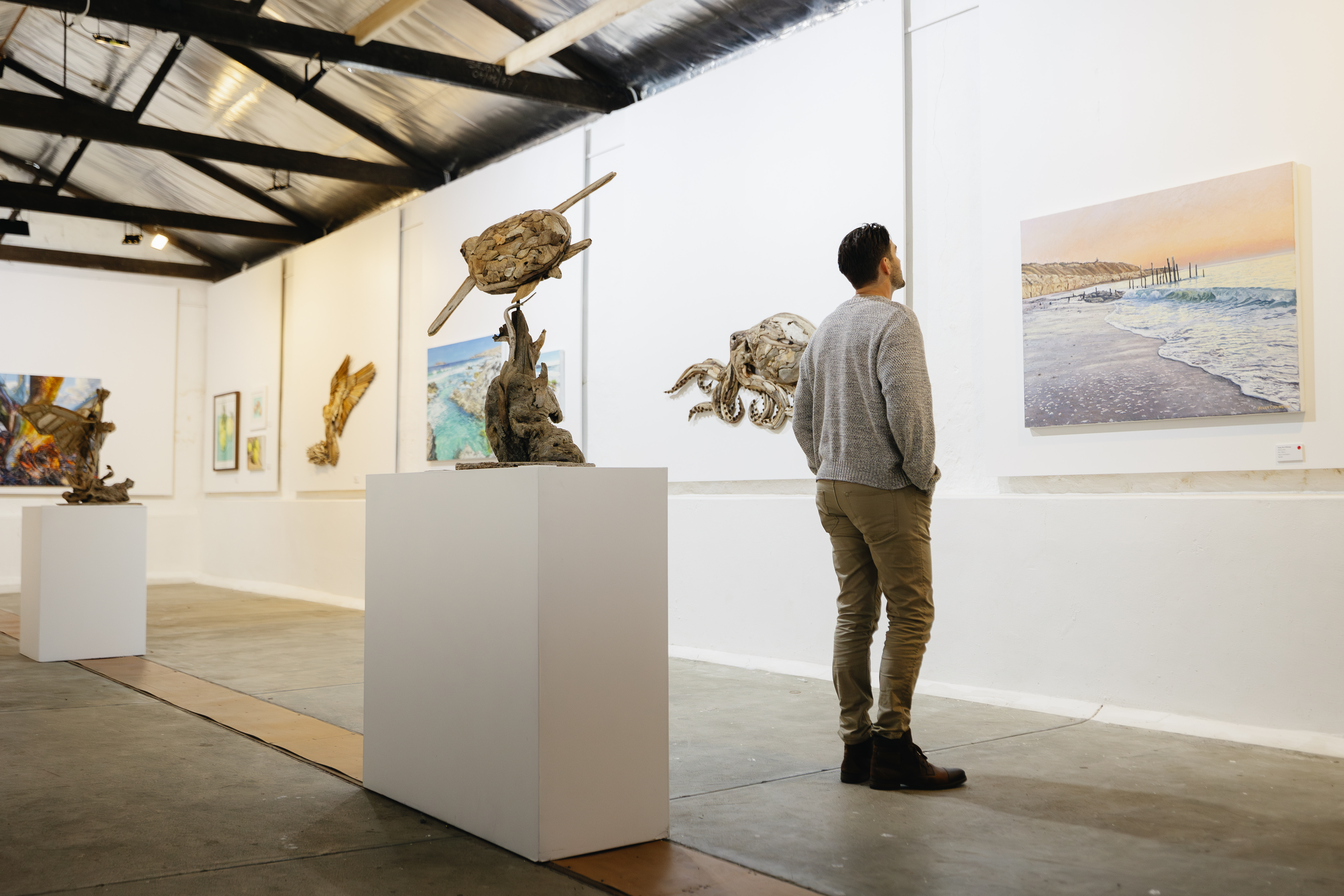 Man standing in the fleurieu arthouse gallery looking at a picture on the wall