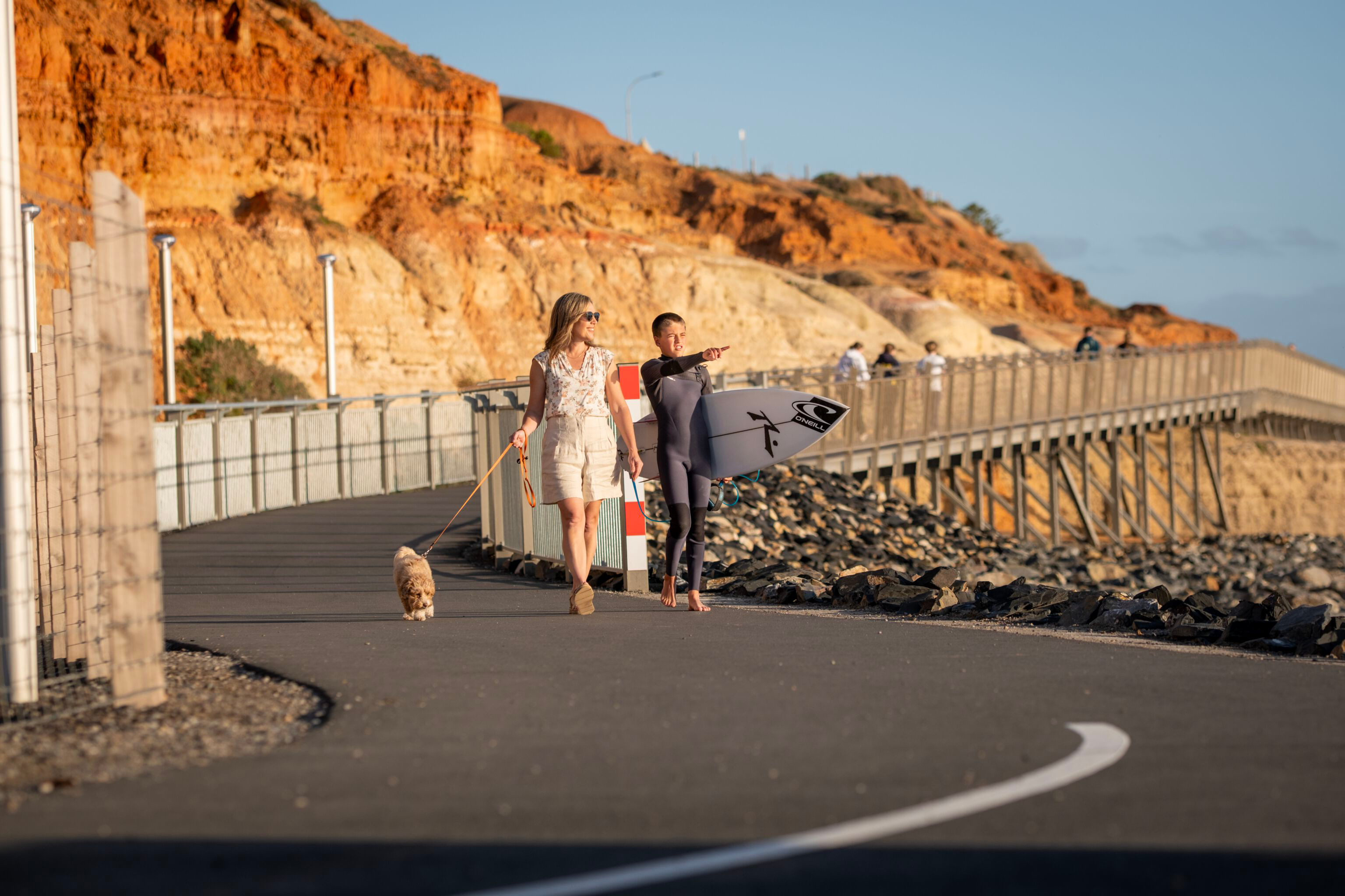 Adele and Seth walking with their dog along the Witton Bluff Base Trail at Christies Beach